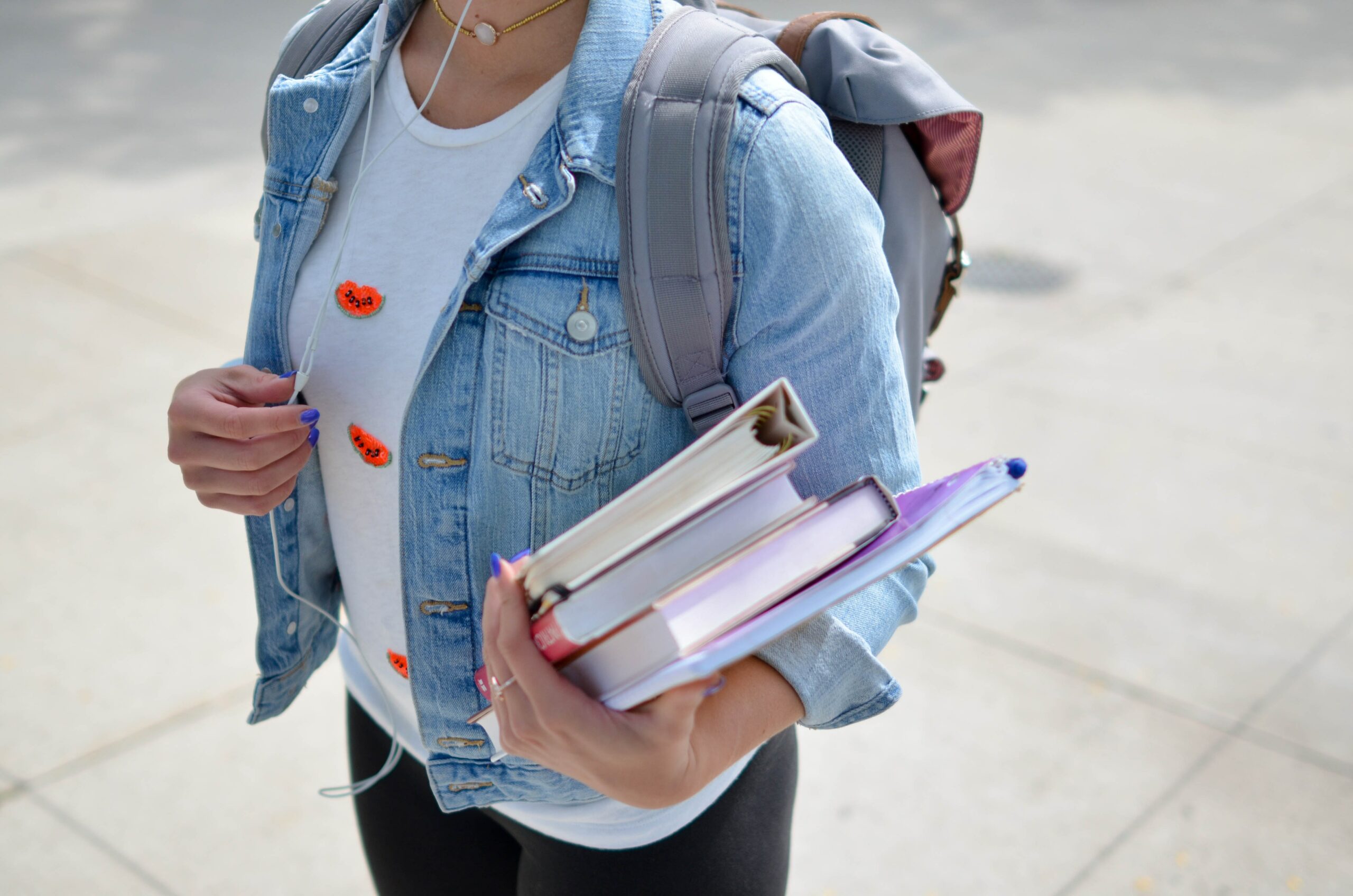 student holding books and back pack