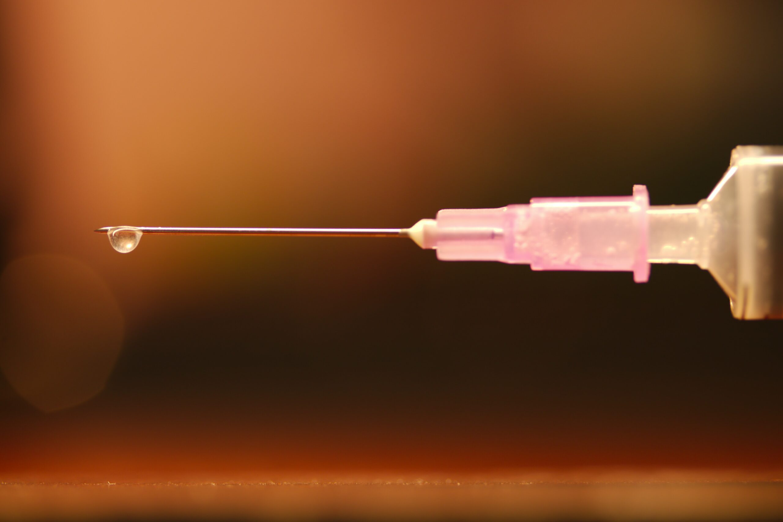 Needle with drop of liquid substance coming out