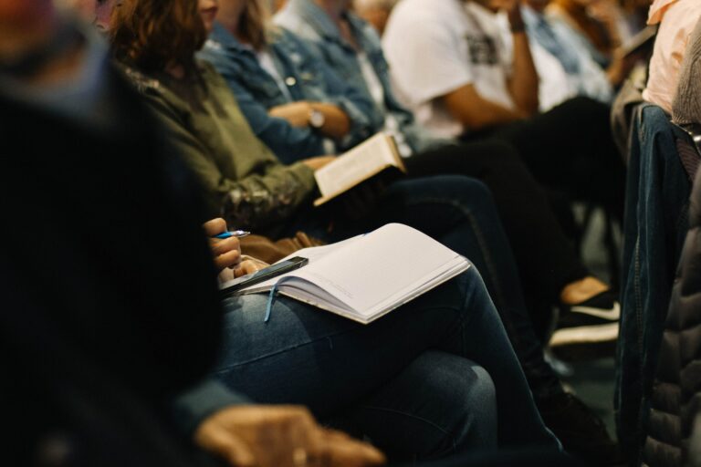 Audience in lecture taking notes