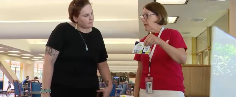 older woman showing another woman naloxone in a cafeteria